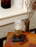 white flickering flameless candle with personalized label on a wood table